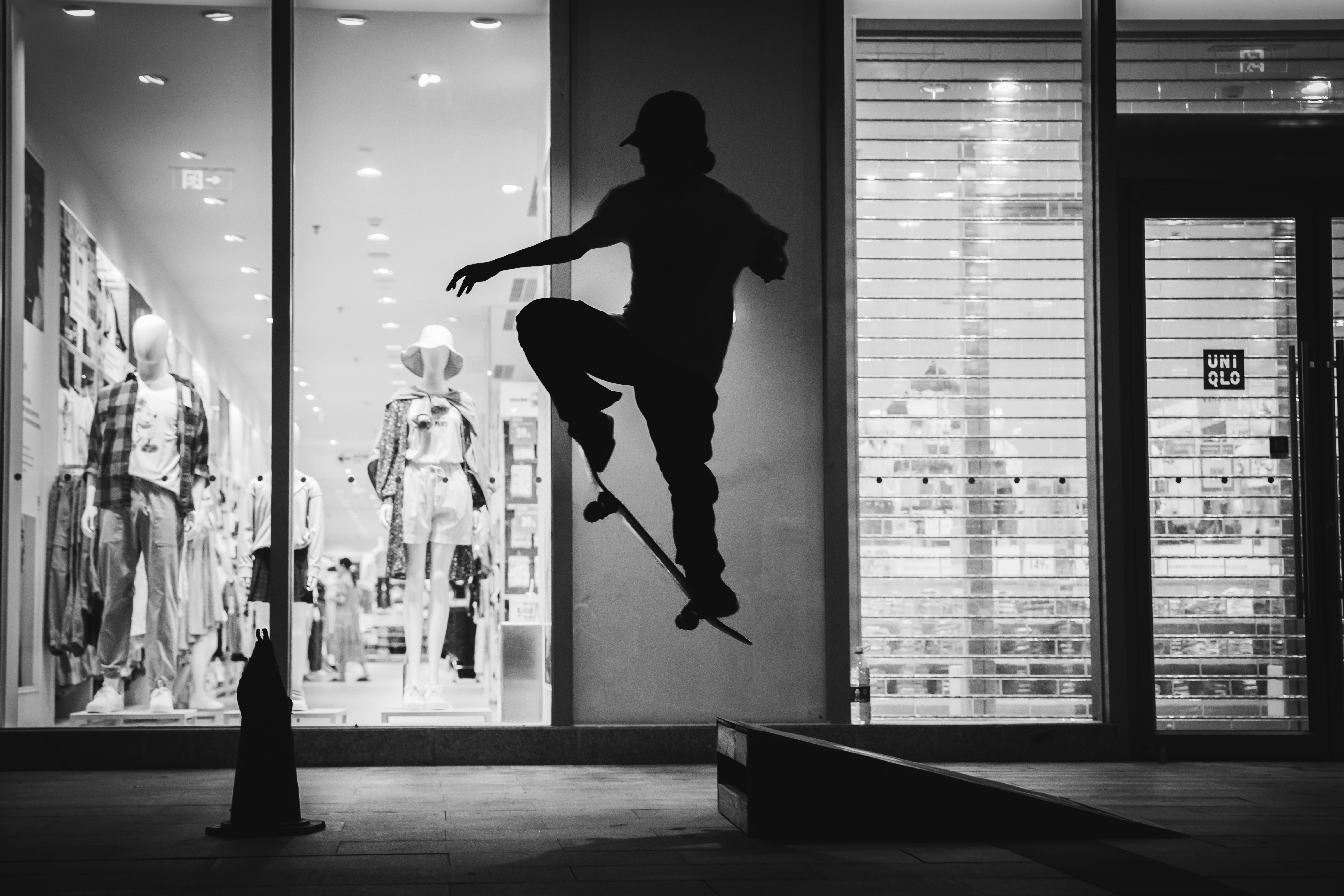 A skateboarder doing a trick in a skateboard shop photo Free Grey