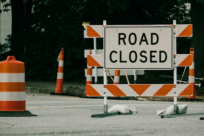 Road sign with orange traffic cones marking an active construction zone