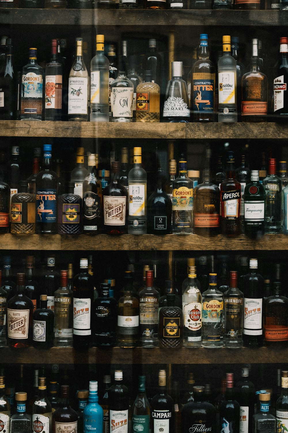 a shelf with many bottles of alcohol on it
