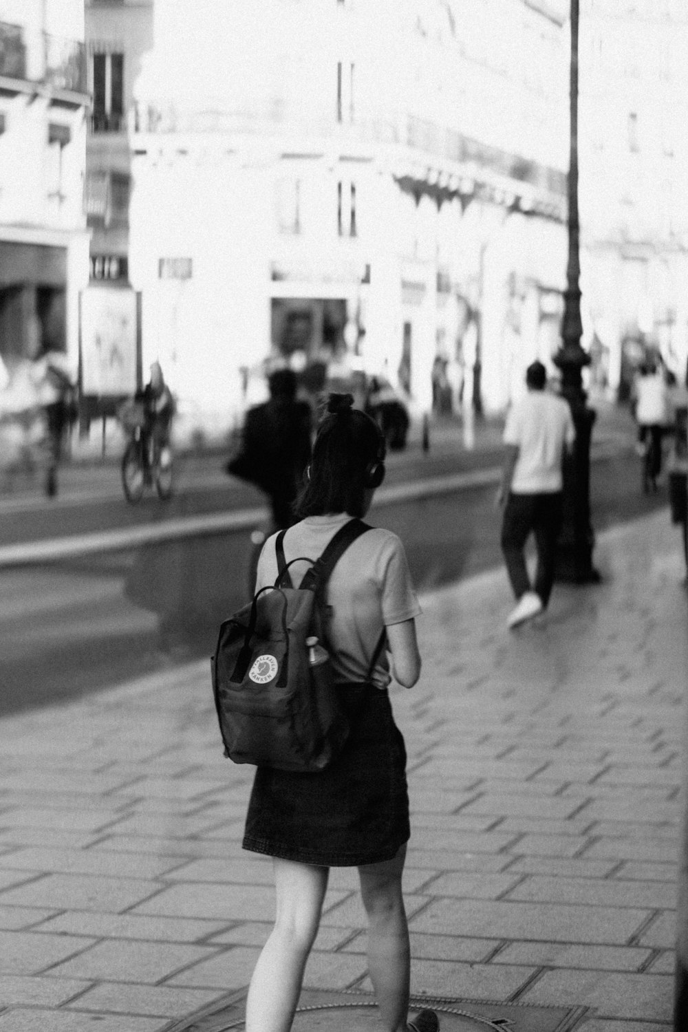 uma mulher que carrega um saco andando por uma calçada