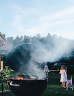 Family enjoying a BBQ under the open sky near the villa.