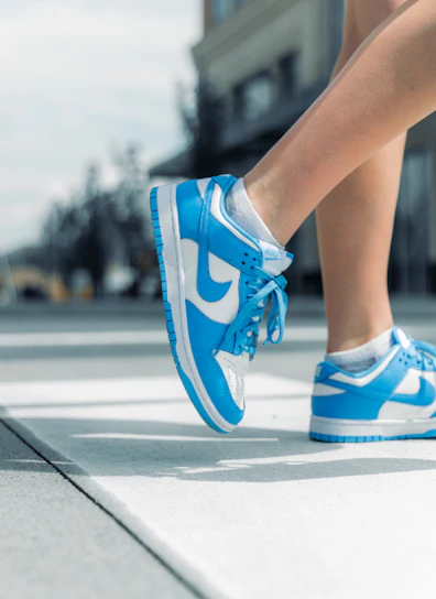Lifestyle image showing a person walking confidently in blyth sneakers on a city street with soft natural light.