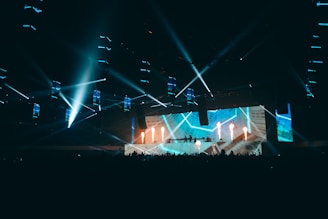 a stage with a large screen and a crowd of people