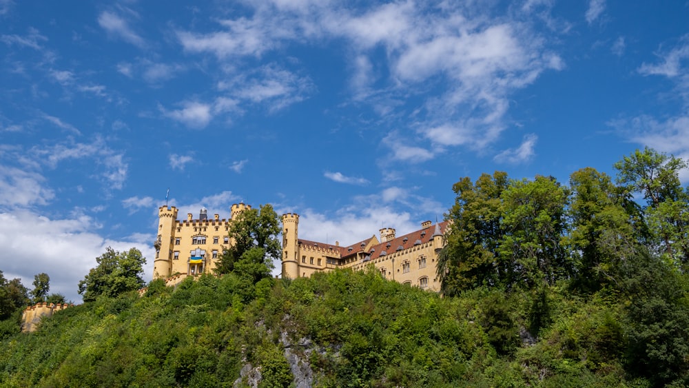 Un gran edificio en la cima de una colina con árboles a su alrededor