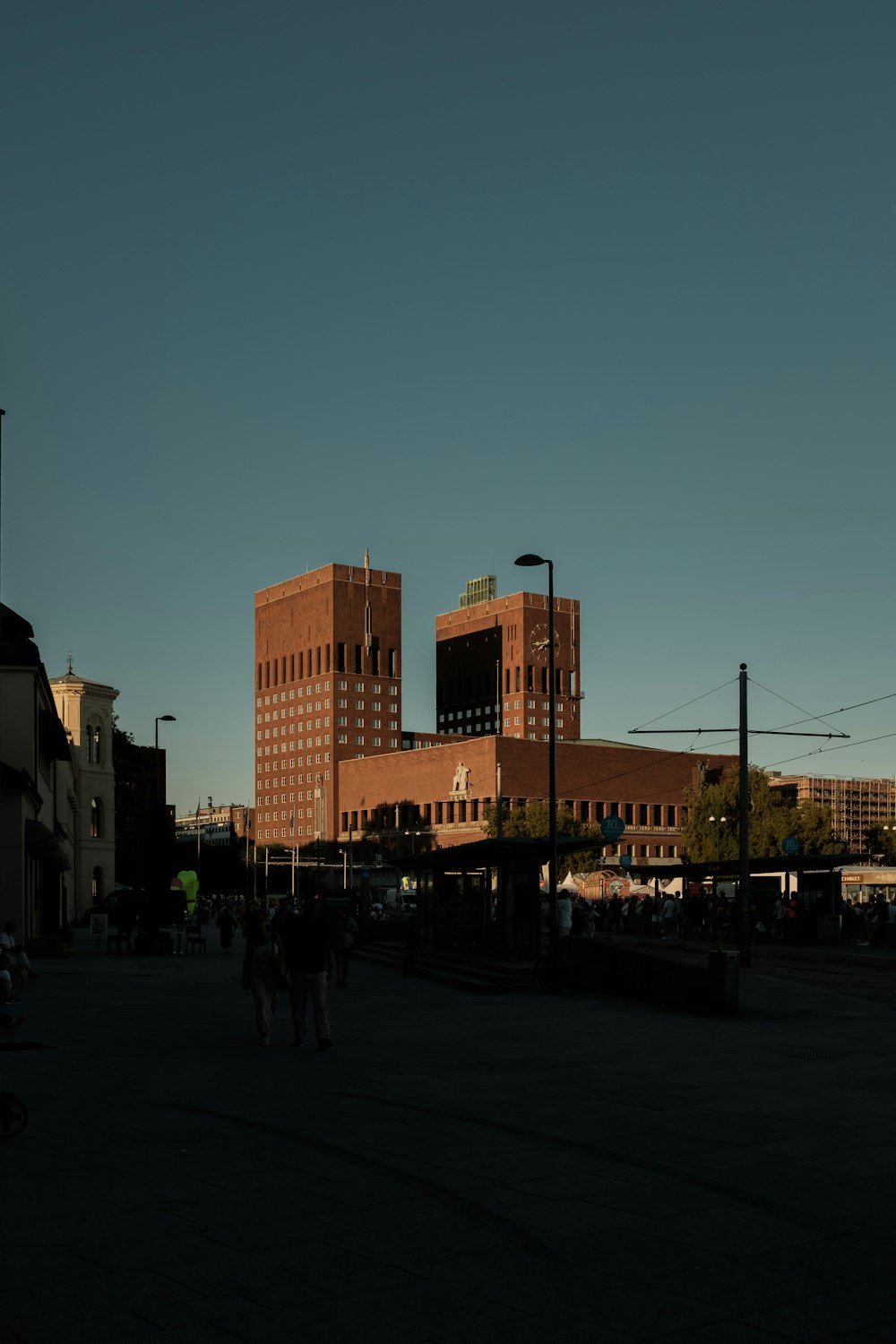 a group of people walking on a street with buildings in the background