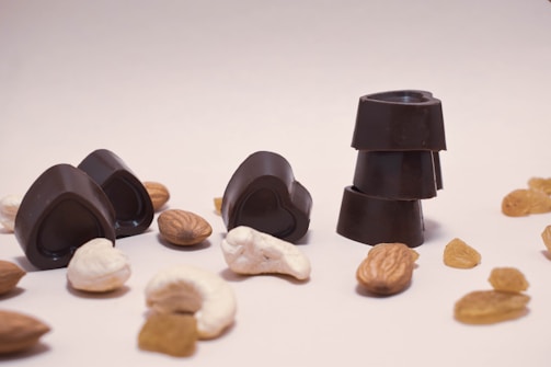 Assorted chocolates with nuts and dried fruits arranged on a rustic wooden board.