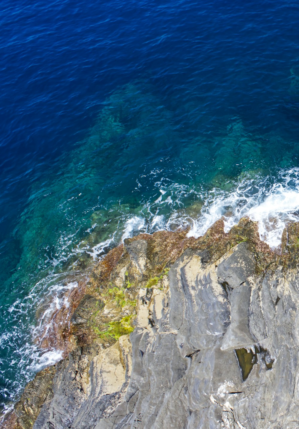 a rocky cliff with waves crashing against it