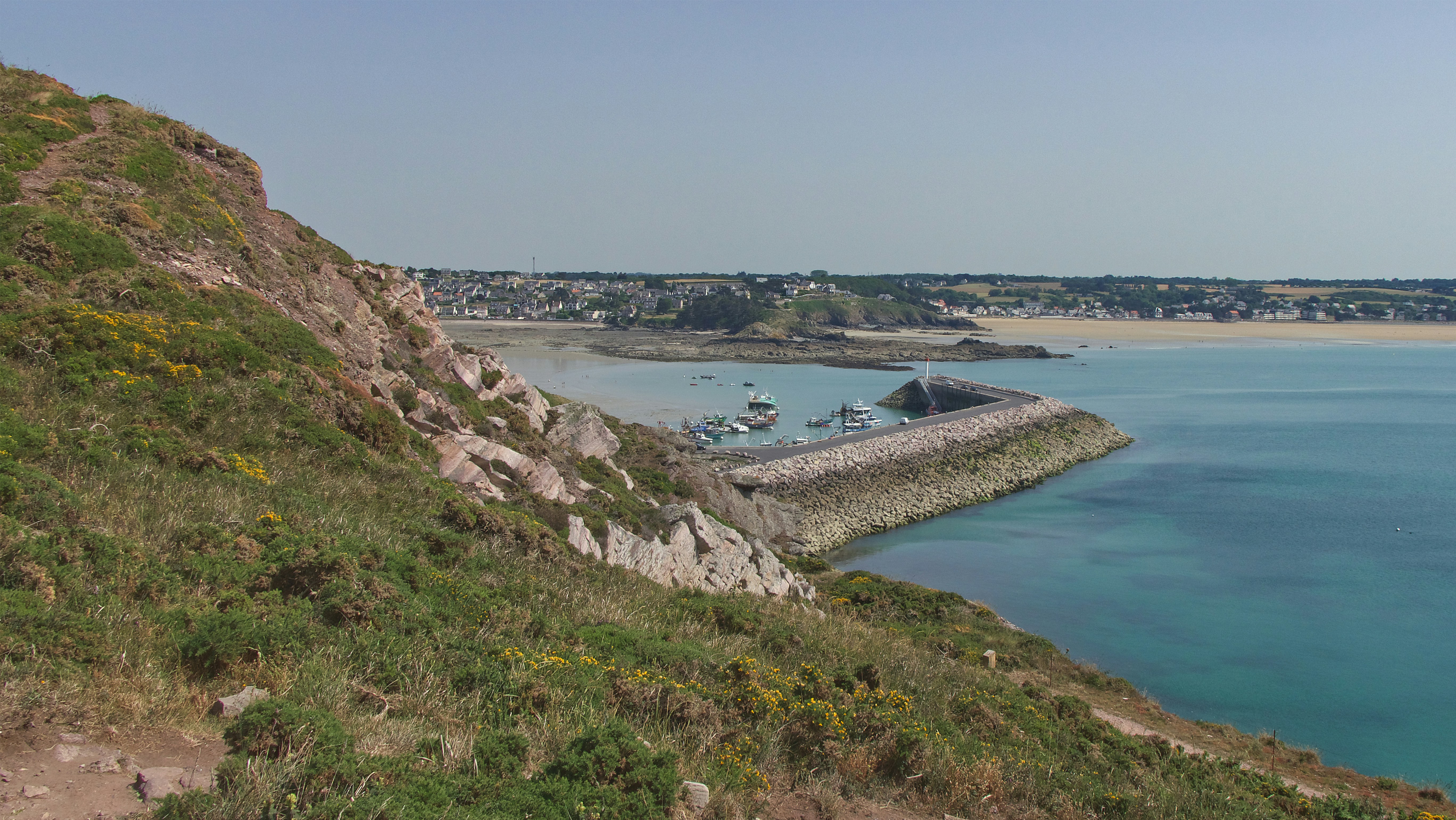 a body of water with a land with a beach and buildings