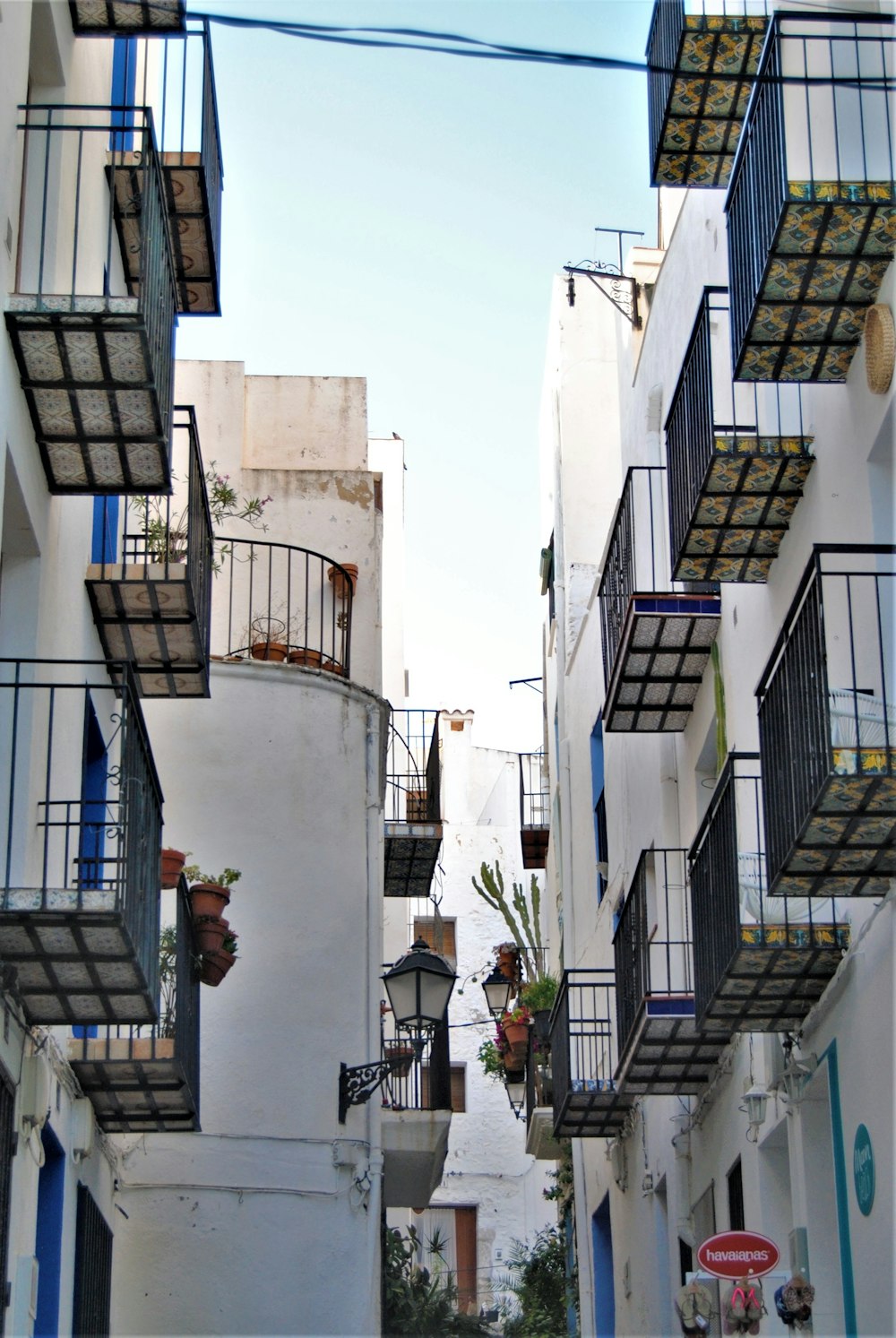 a row of buildings with balconies and plants on the side