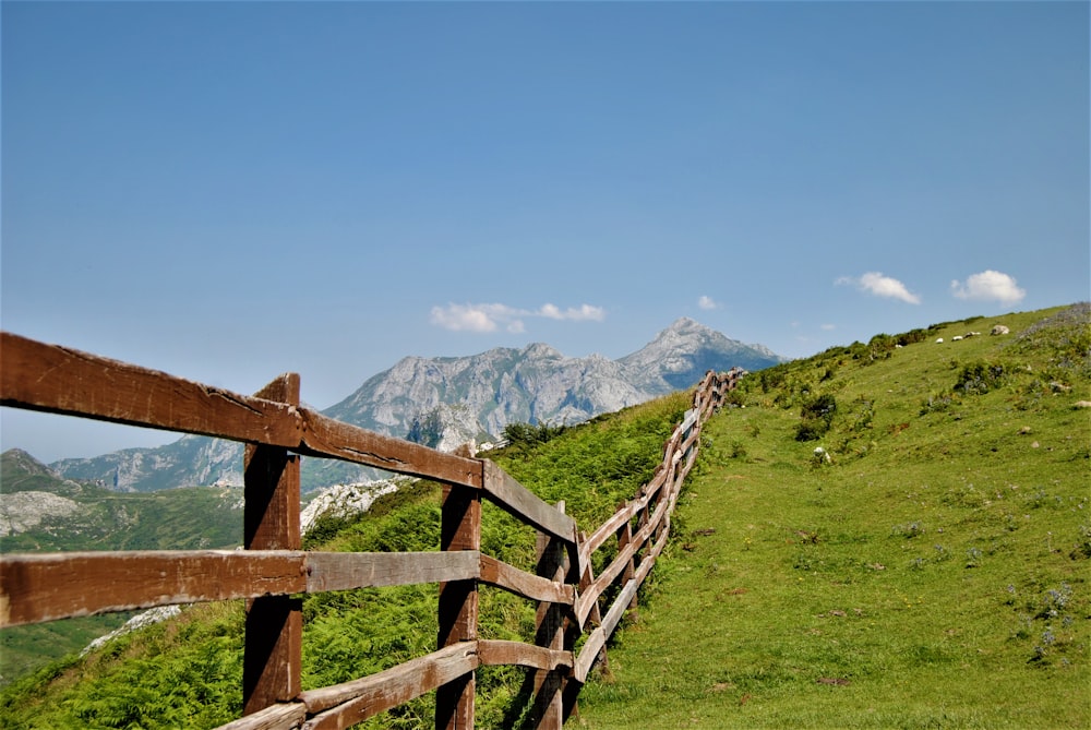 a wooden fence in front of a mountain
