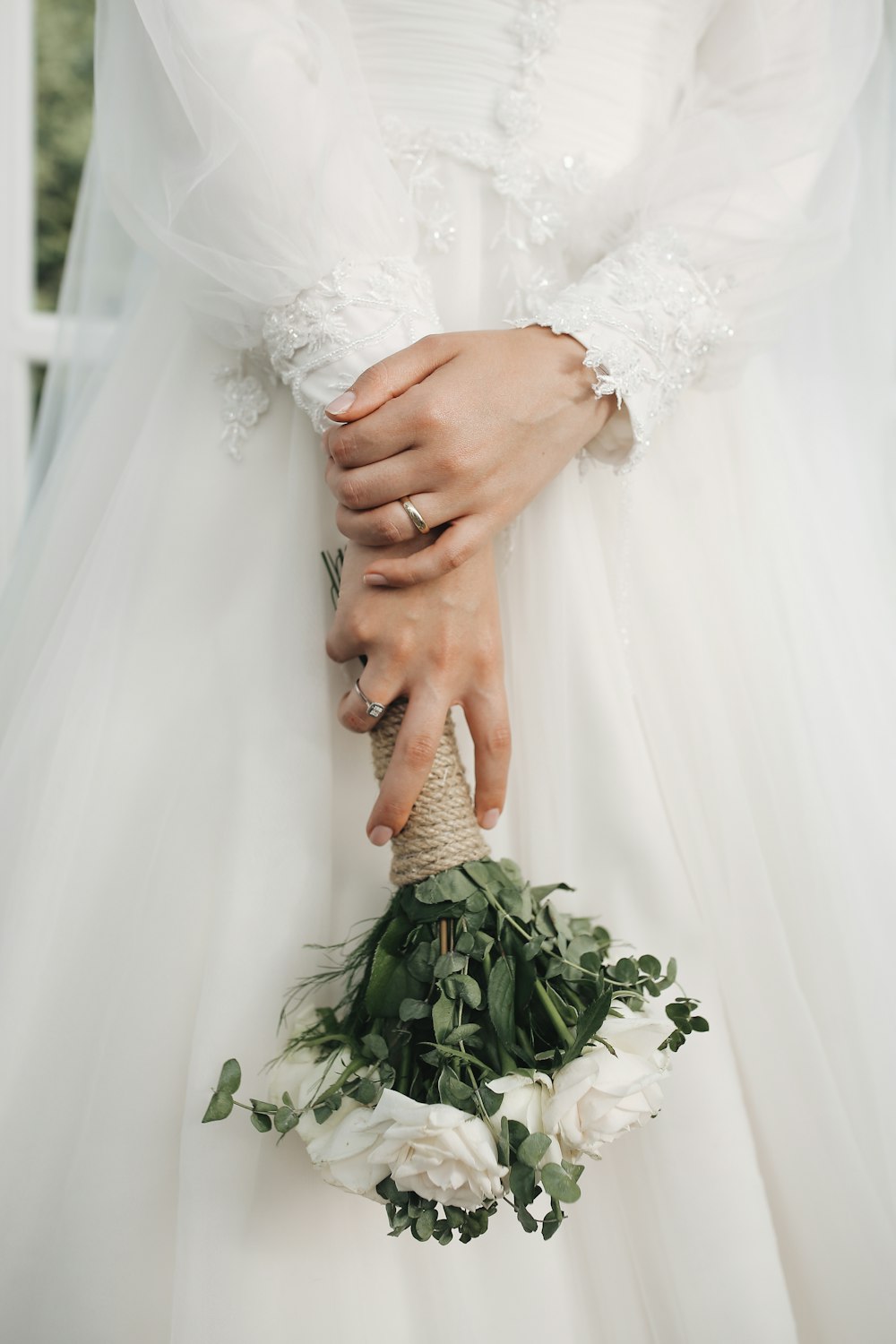 una persona in un vestito bianco che tiene le mani unite