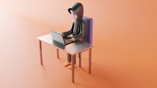 a person sitting at a desk with a laptop on it