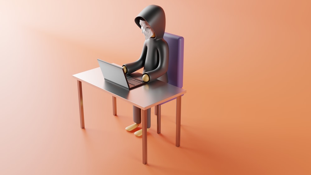 Eine Person, die mit einem Laptop an einem Schreibtisch sitzt