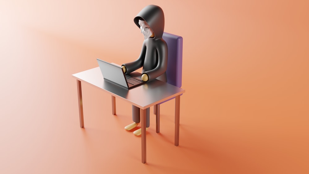 une personne assise à un bureau avec un ordinateur portable dessus