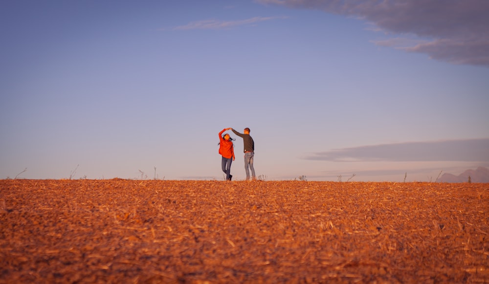 a man and woman standing in a field