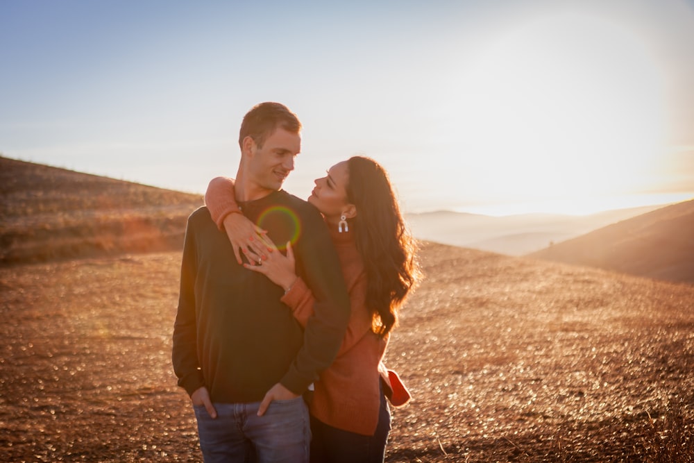 a man and woman holding each other and smiling