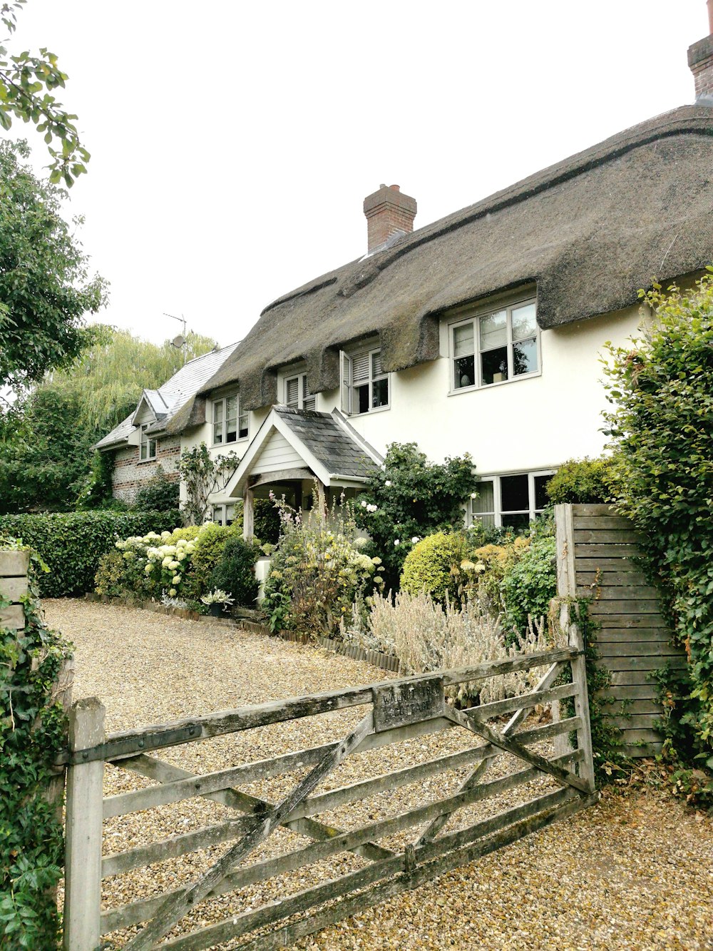 a house with a fence and bushes around it