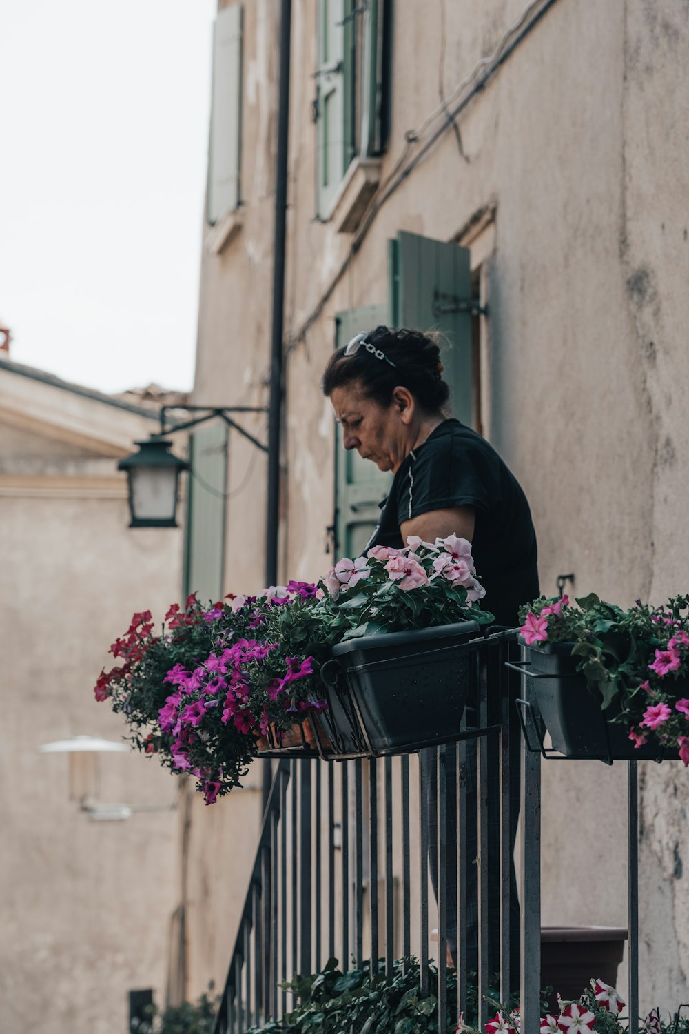 a person standing behind a fence with flowers in front of him