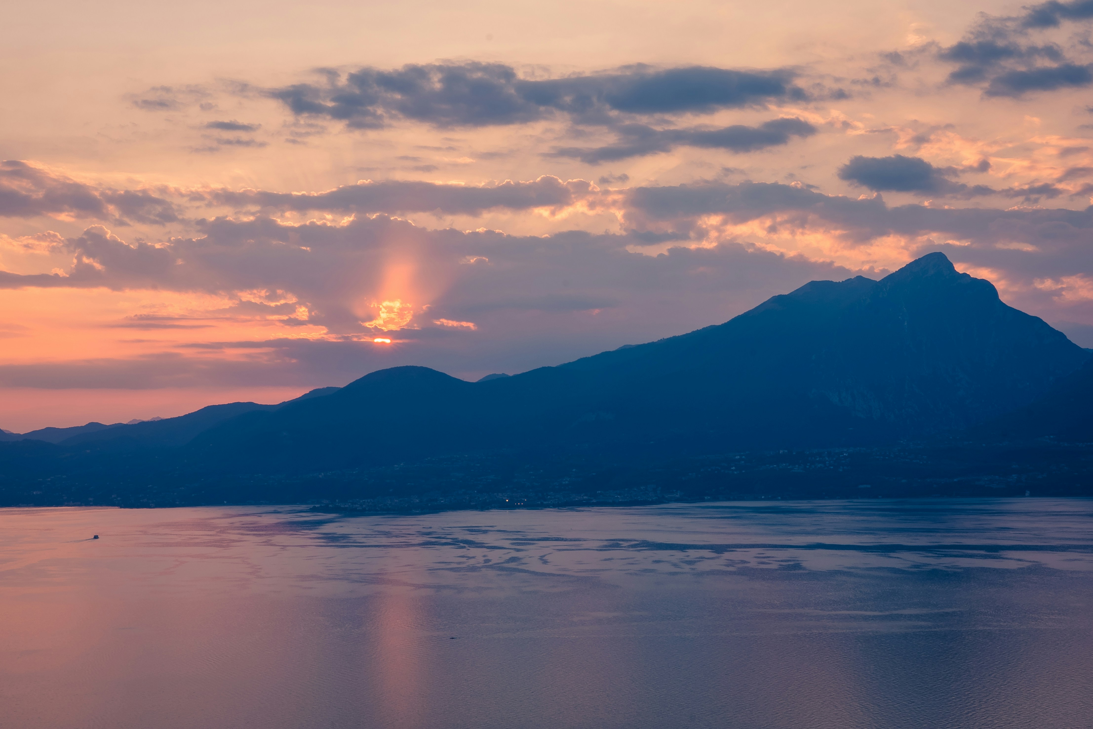 a body of water with mountains in the background, 