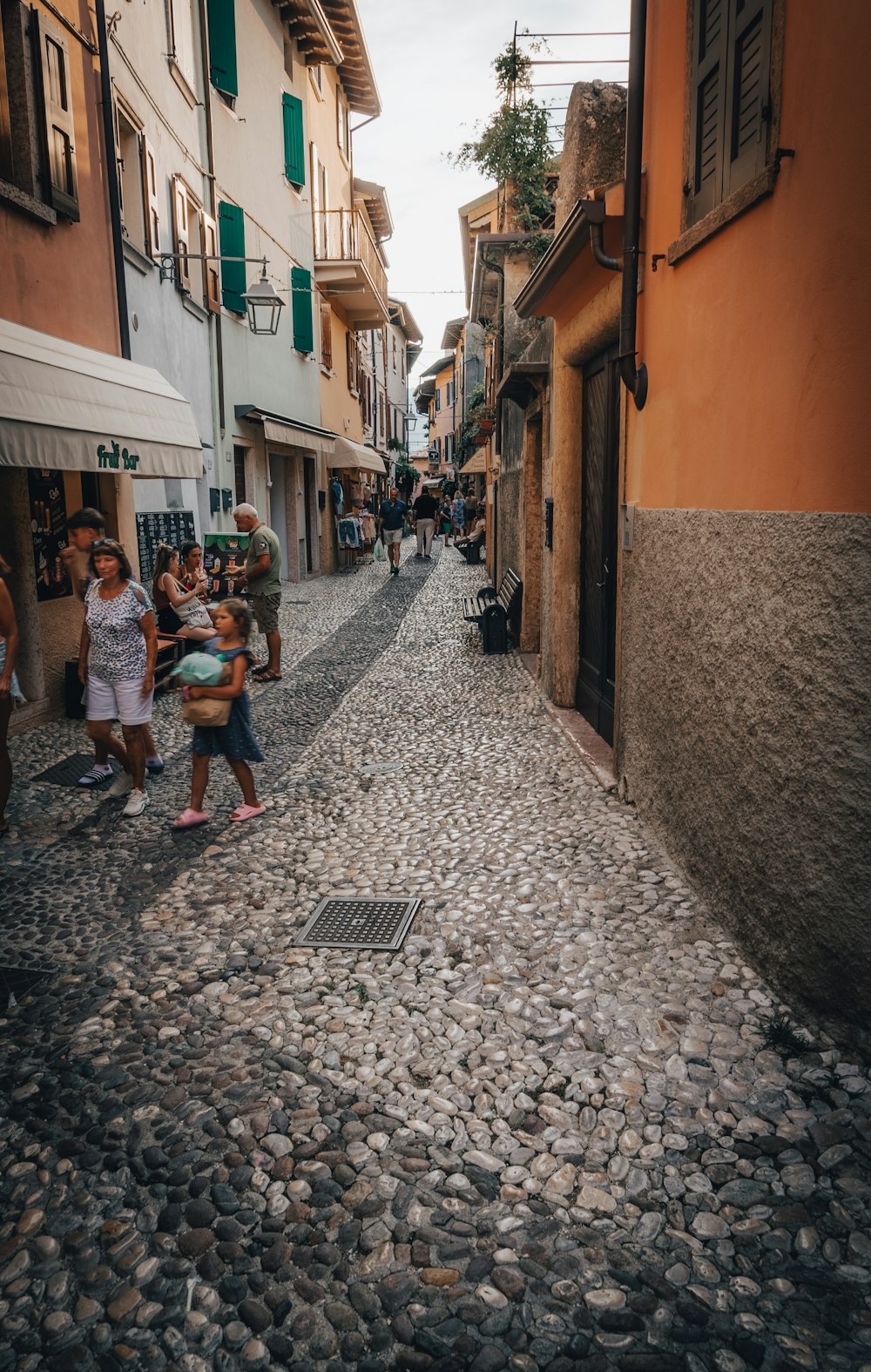 a group of people walking down a cobblestone street