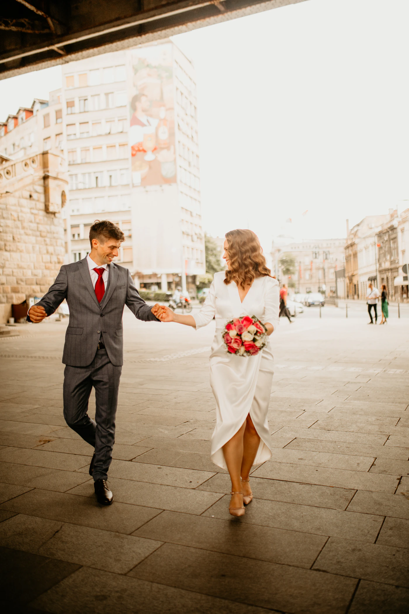 Couple in elopement attire on the lower level of the Dufferin Terrace with the Chateau Frontenac filling the upper portion of the frame above them