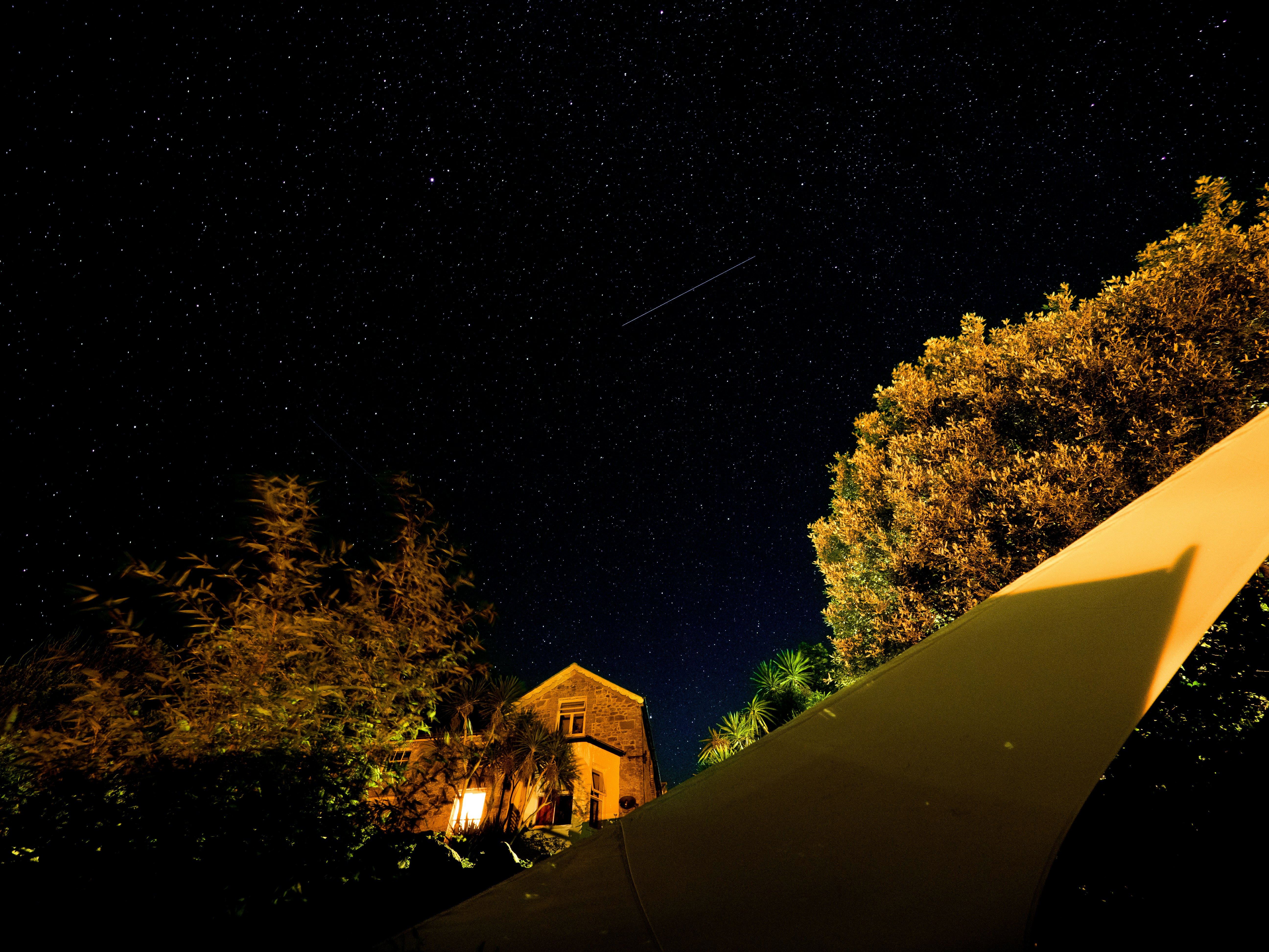 a house with a yellow tent in the background at night