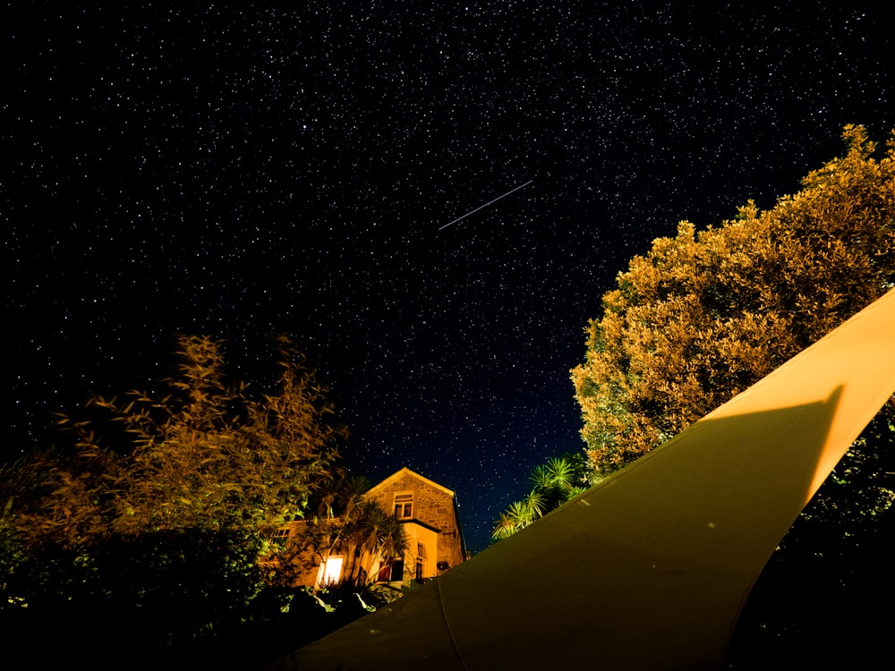 a house with a yellow tent in the background at night