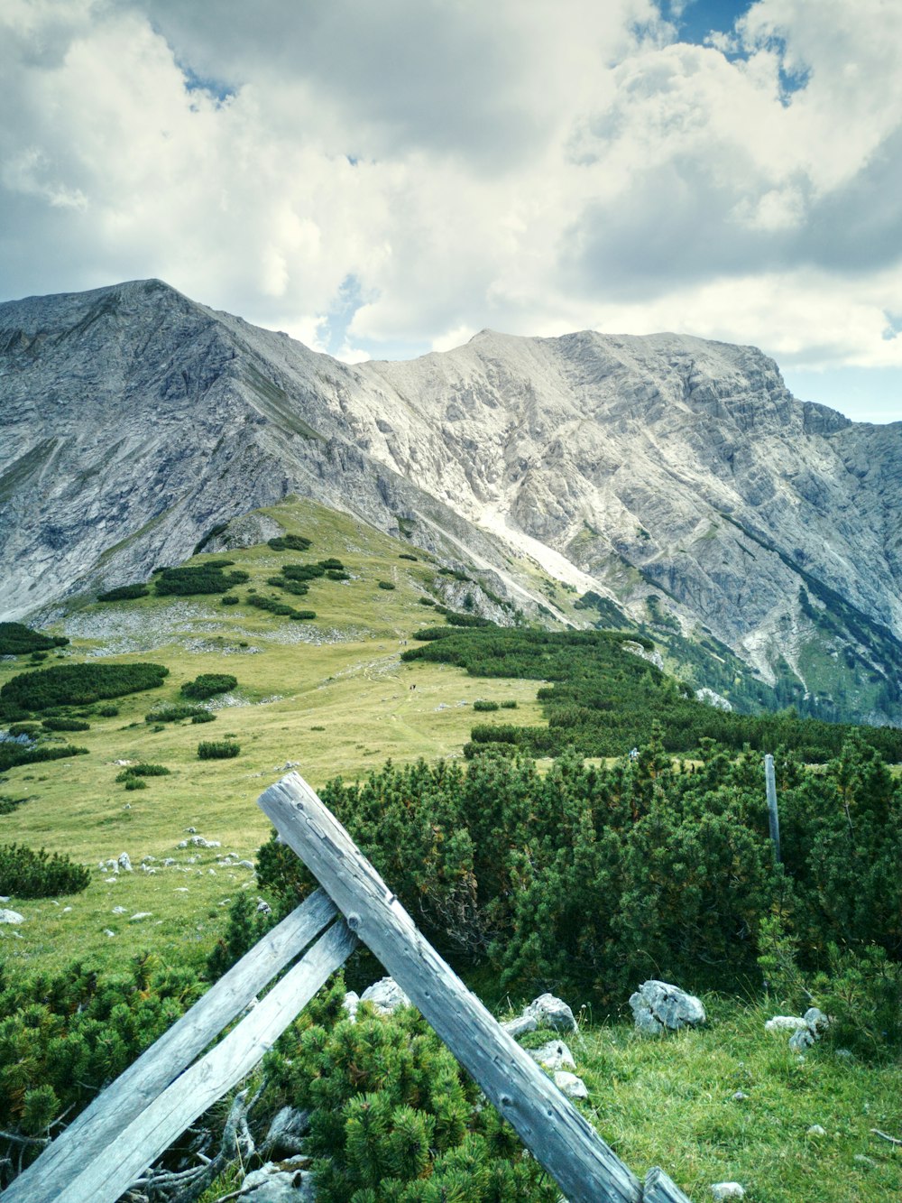 a wooden fence in front of a mountain