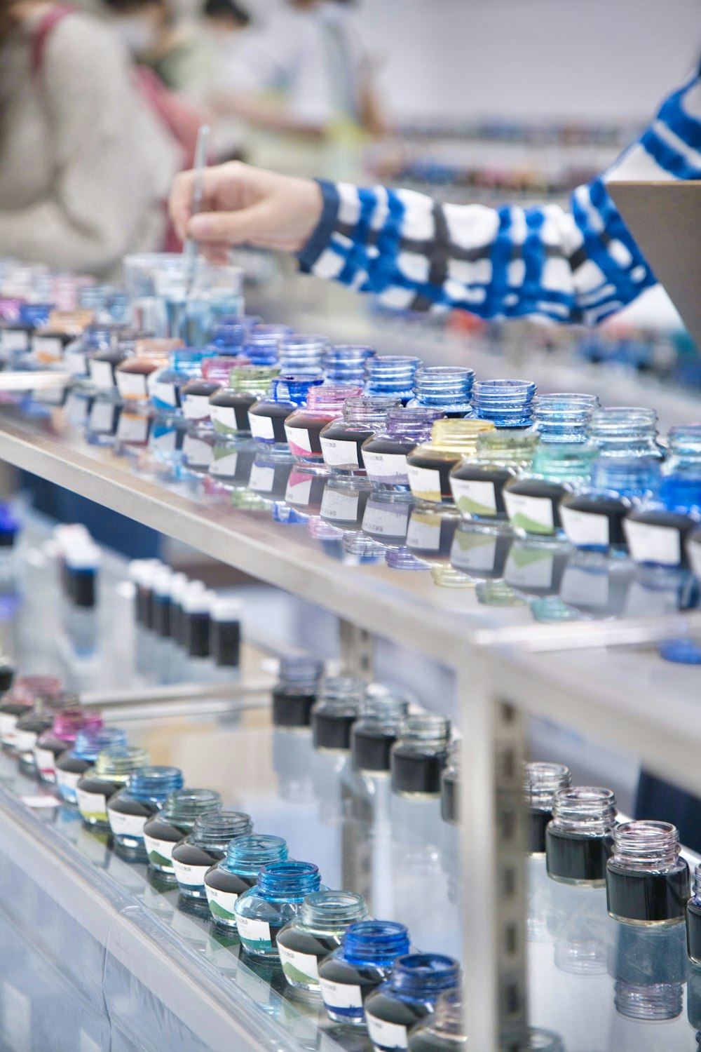 a person touching a shelf of bottles