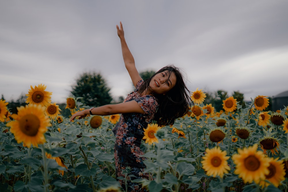 una persona in posa in un campo di girasoli