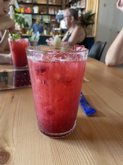 Close-up of a refreshing glass of fresh sugarcane juice on a rustic wooden table