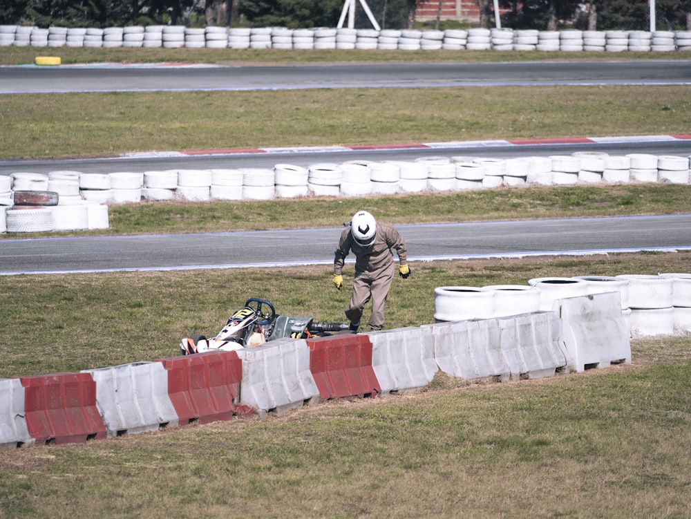 Una persona con un casco blanco caminando en una pista de carreras