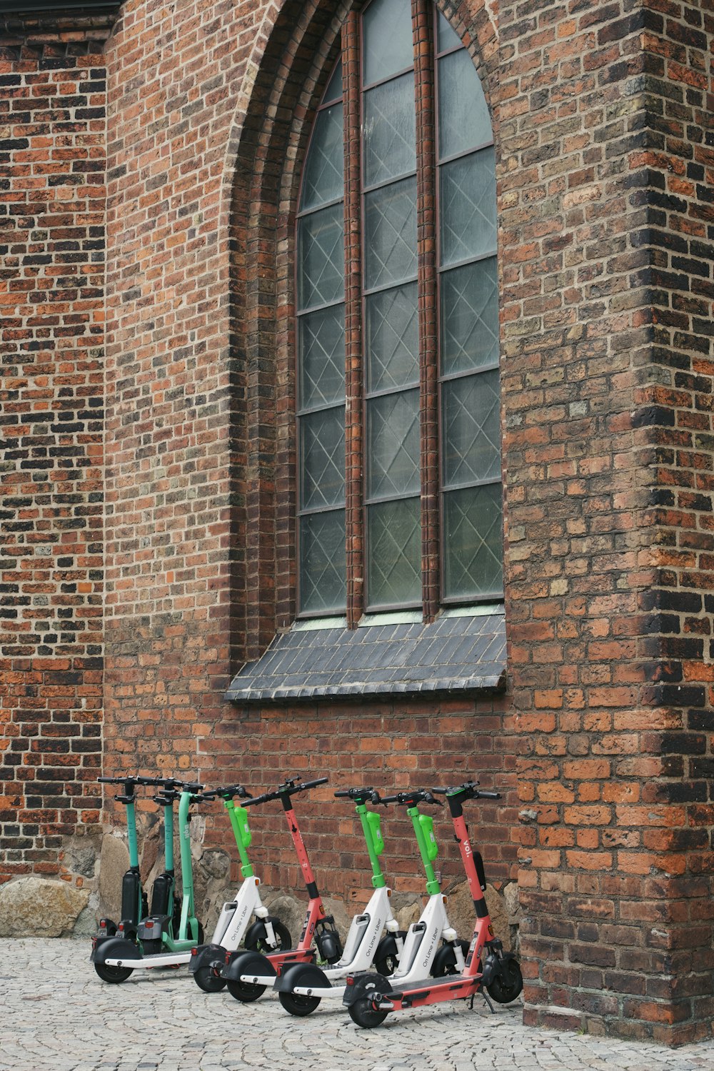 a brick building with a bike rack and tools in front of it