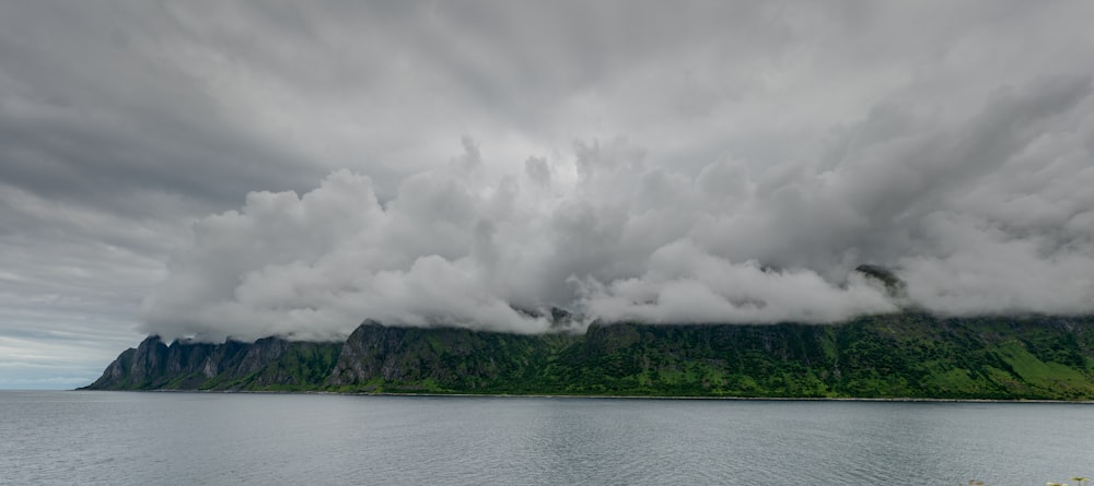 a large island with trees and clouds above it