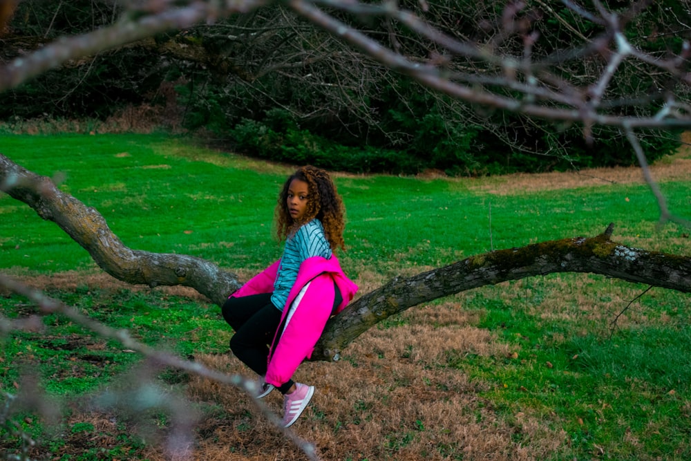 una persona sentada en la rama de un árbol