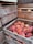 Wooden crates are stacked, filled with ripe peaches. The crates have a rustic appearance, and some are labeled with 'DURGIN' followed by a phone number. The peaches are vibrant with shades of orange and red, nestled snugly within the crates.
