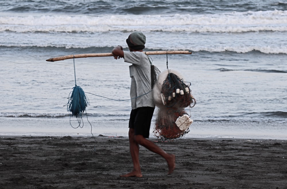 a person carrying a dog on a beach