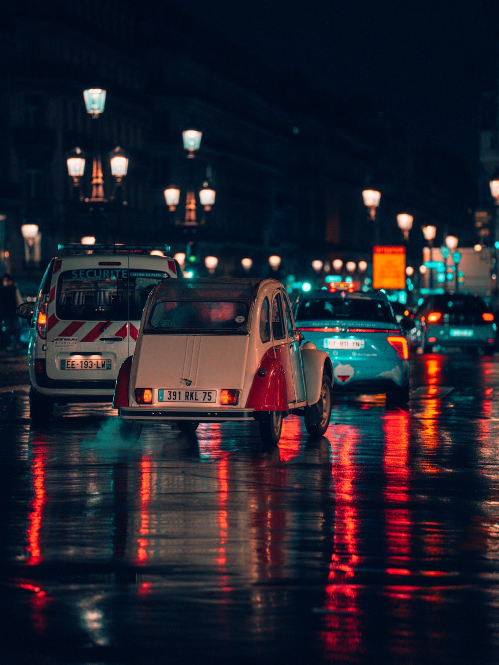 a group of cars on a wet road at night