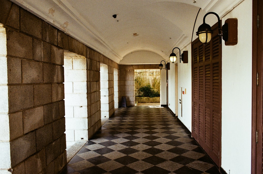 a hallway with a brick wall and a door with lights