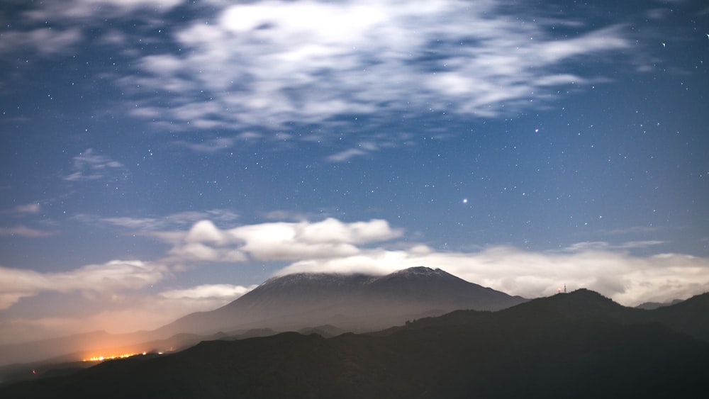 a mountain with clouds in the sky