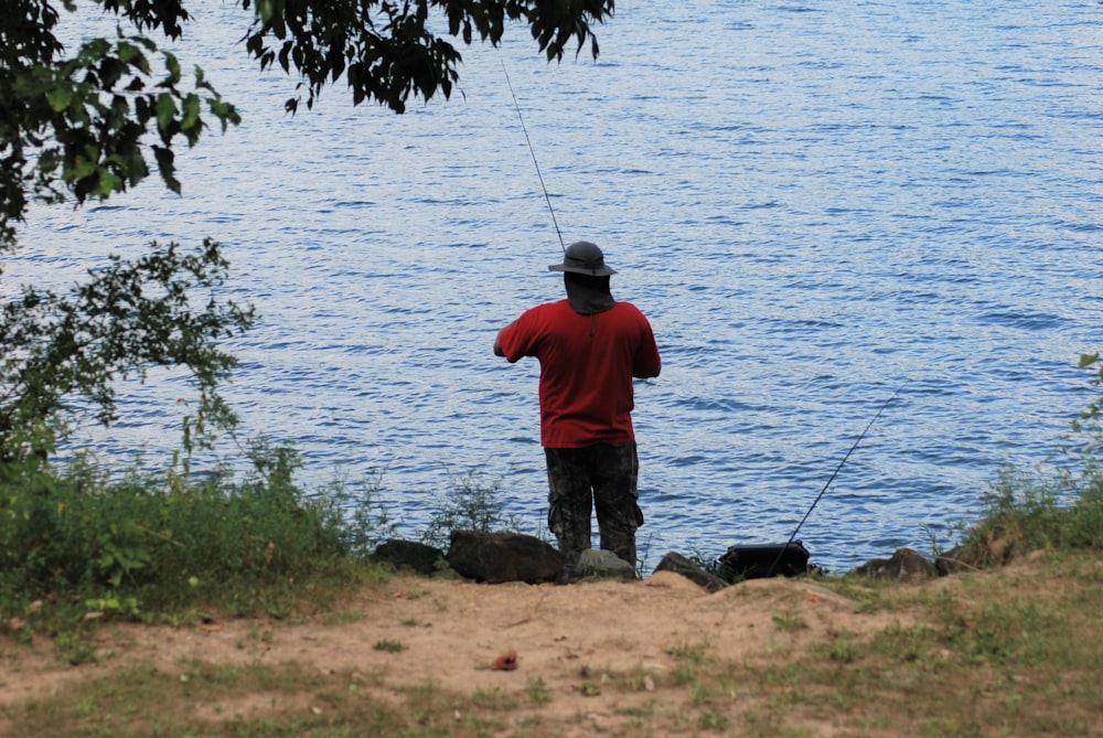 a man standing next to a body of water