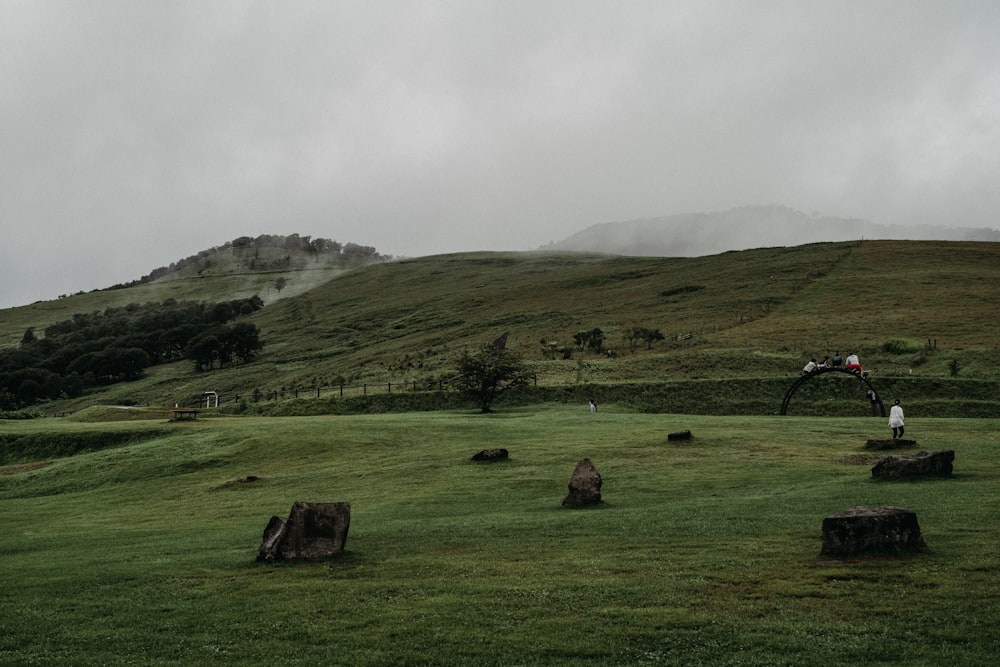 a person on a bicycle in a grassy field with hills in the background