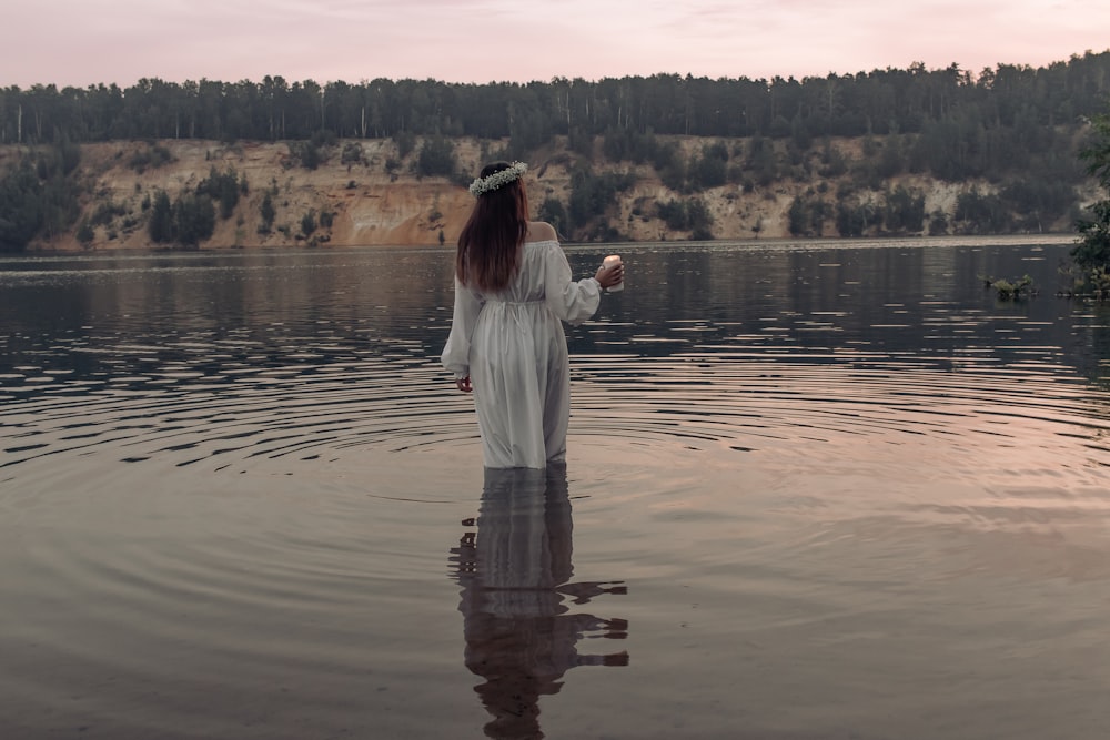 a person standing in a body of water with trees in the background