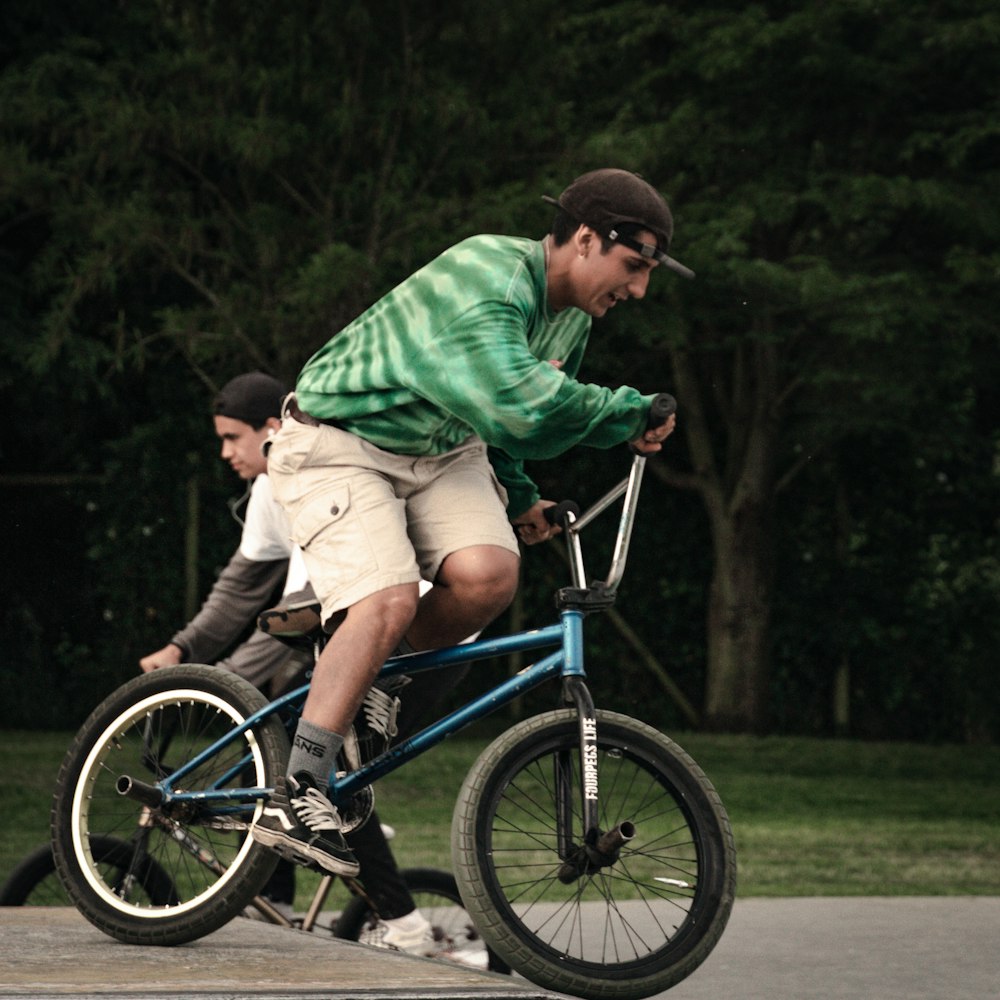 a person riding a bicycle with a boy on the back