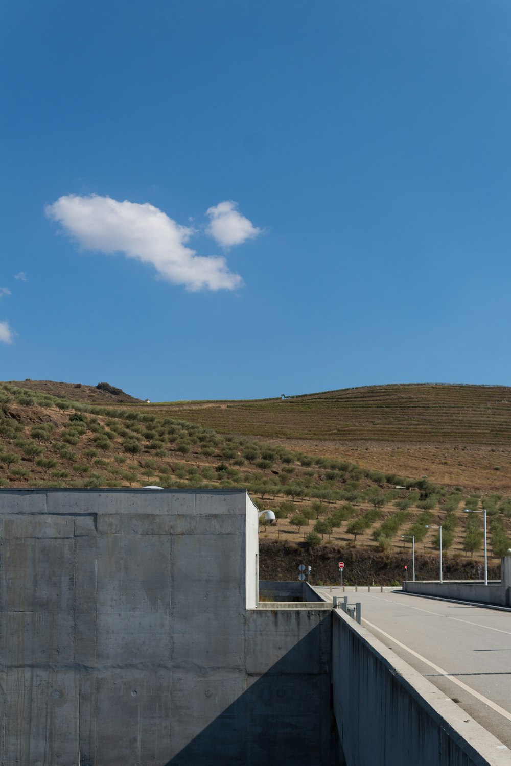 uma parede de concreto com uma colina no fundo