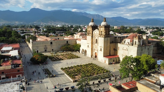 a large building with a dome and a courtyard with people walking around