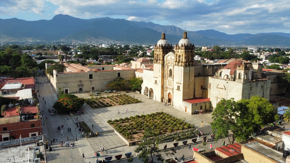 a large building with a dome and a courtyard with people walking around