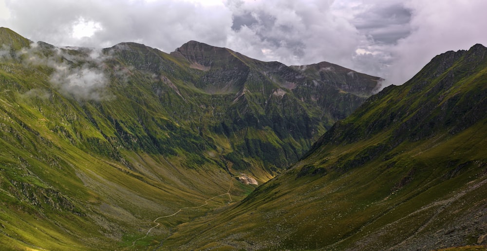 a grassy mountain with clouds