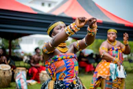 A couple watching a vibrant cultural dance performance beside the Tungabhadra River.