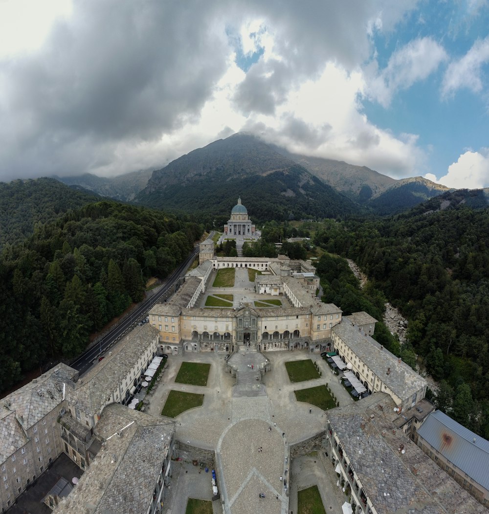 uma grande estrutura de pedra com uma torre e árvores ao fundo